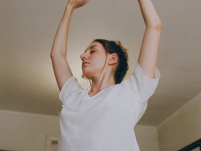 A gentle stretching pose in a bright room.